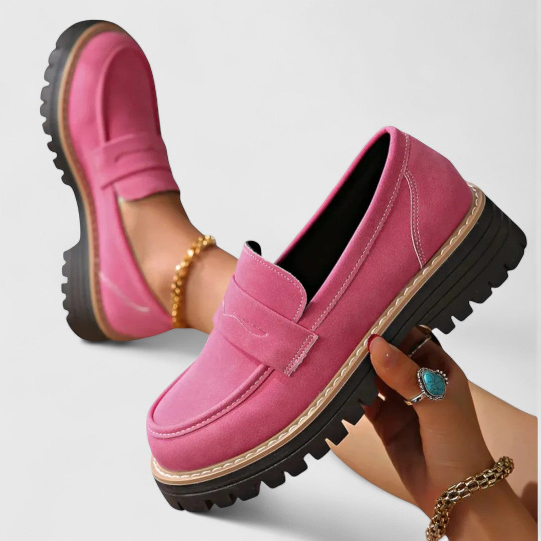 Rosa loafers med tjock sula, ena skon hålls i handen och andra bärs 3
