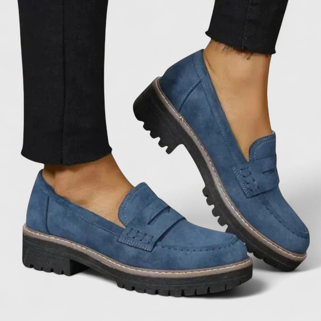 Blå loafers i mockaliknande material, bärs med svarta byxor, sedda från sidan 4