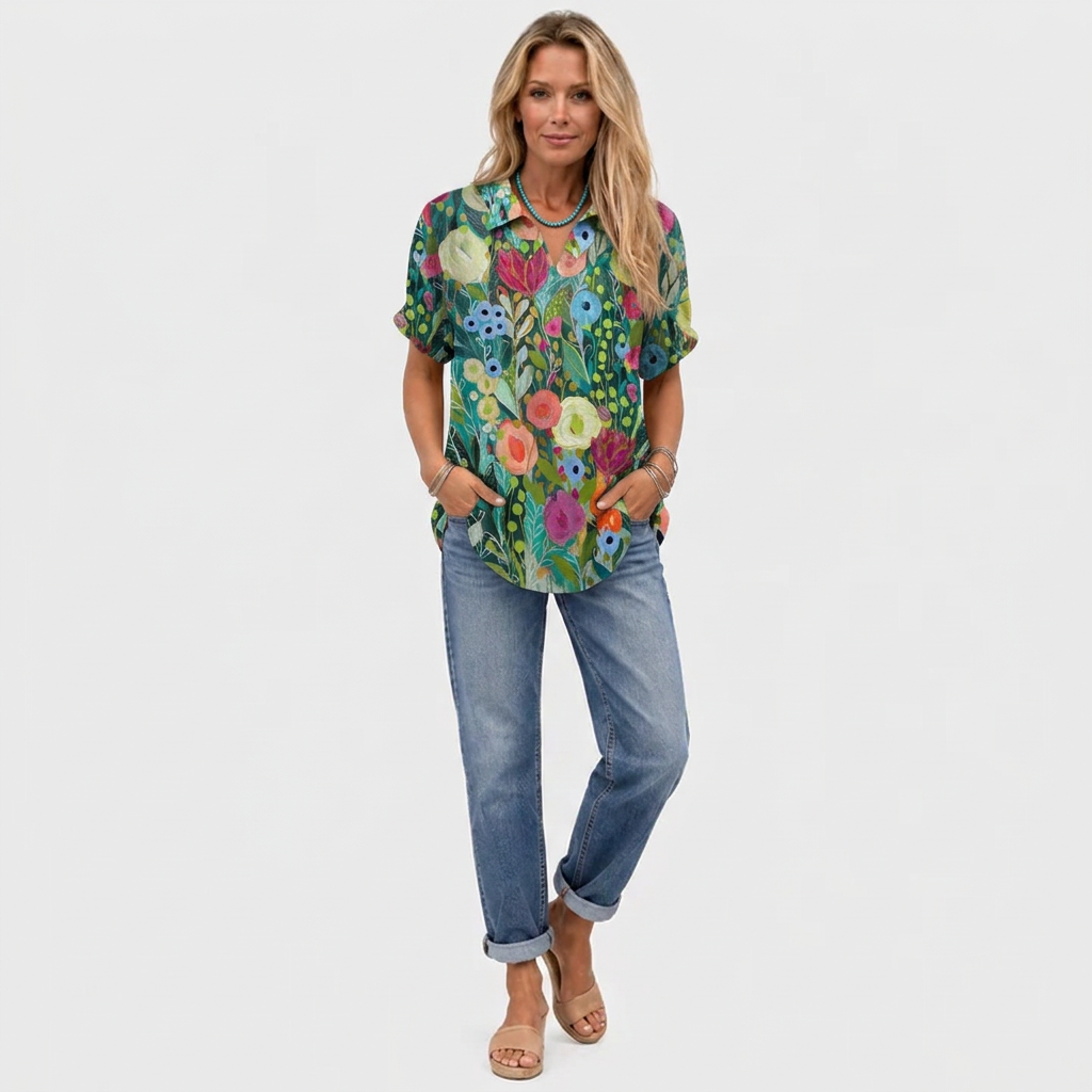 Helbild av modell i toppen med jeans och sandaler, ledig passform och blommönstret syns 2