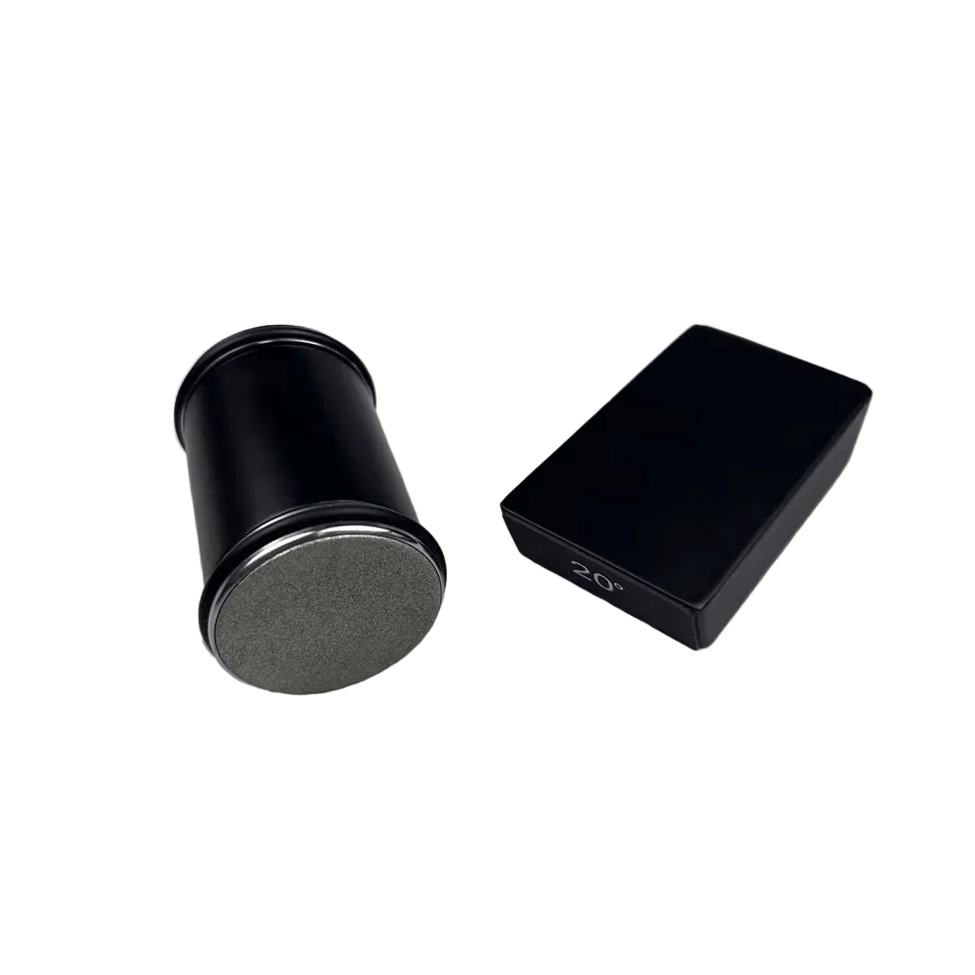 Svart version med slipcylinder som visar sitt gråa diamantbelagda slipplan, bredvid ett svart rektangulärt vinkelblock med gradmarkering. 1