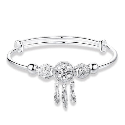 Silbernes Damenarmband mit Kreuzanhänger und Federn, elegantes Schmuckdesign.