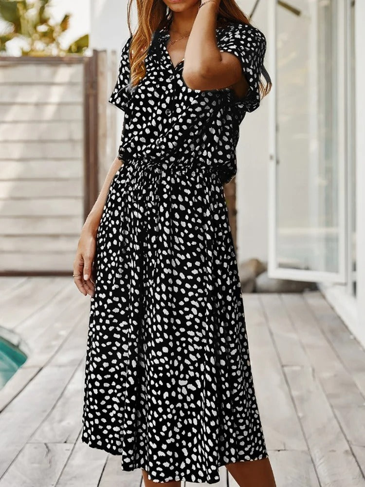 Frau in schwarz-weiß gepunktetem Sommerkleid auf Terrasse, Freizeitmode, Damenbekleidung.
