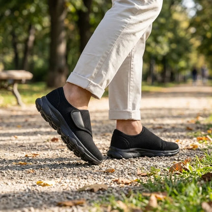 Person i ljusa byxor går på grusstig i parken med helsvarta mesh-skor med kardborreband. 11