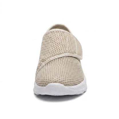 Beige mesh-sko sedd rakt framifrån med kardborrebandet över vristen och vit, rundad sula. 35
