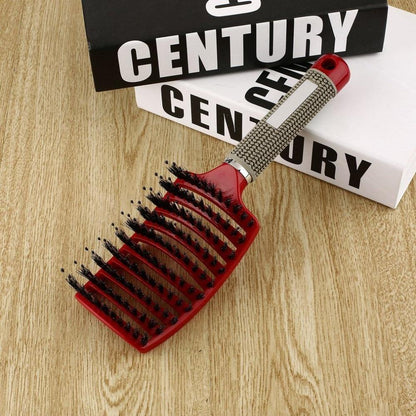 Rote Haarbürste mit ergonomischem Griff auf Holztisch, ideal für Styling und Entwirren.
