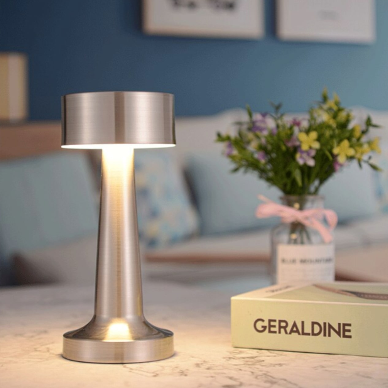 Moderne silberne Tischlampe aus Metall auf Marmortisch im Restaurant, stilvolle Beleuchtung.