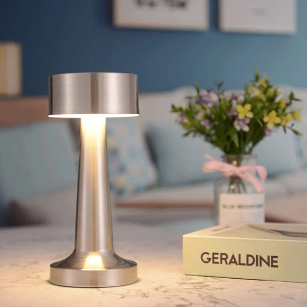 Moderne silberne Tischlampe aus Metall auf Marmortisch im Restaurant, LED-Beleuchtung, stilvoll.