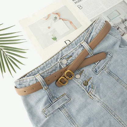 Damen Retro Gürtel, braun, mit Schnalle, auf blauer Jeans, modisches Accessoire, Lederoptik.
