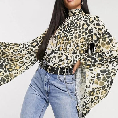 Frau in Leopardenbluse mit ausgestellten Ärmeln, schwarzem Nietengürtel und blauer Jeans.