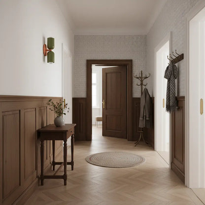 Vägglampa i grönt med orange fäste i en hall med träpanel, sidobord, hattstã¤ll och sillbensparkett. 7