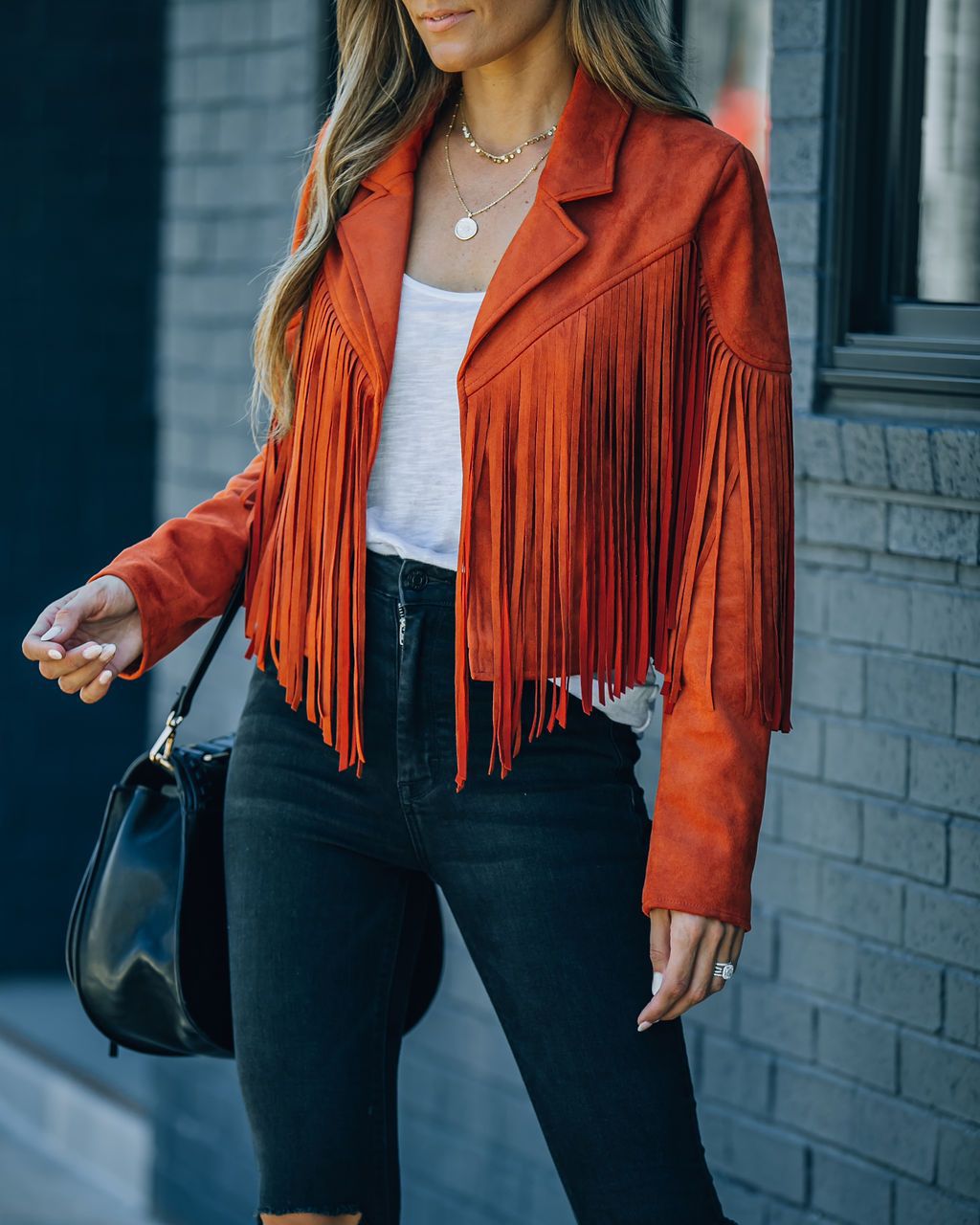 Frau in roter Fransenjacke aus Wildleder, modisch, trendig, Damenmode, Herbstoutfit.