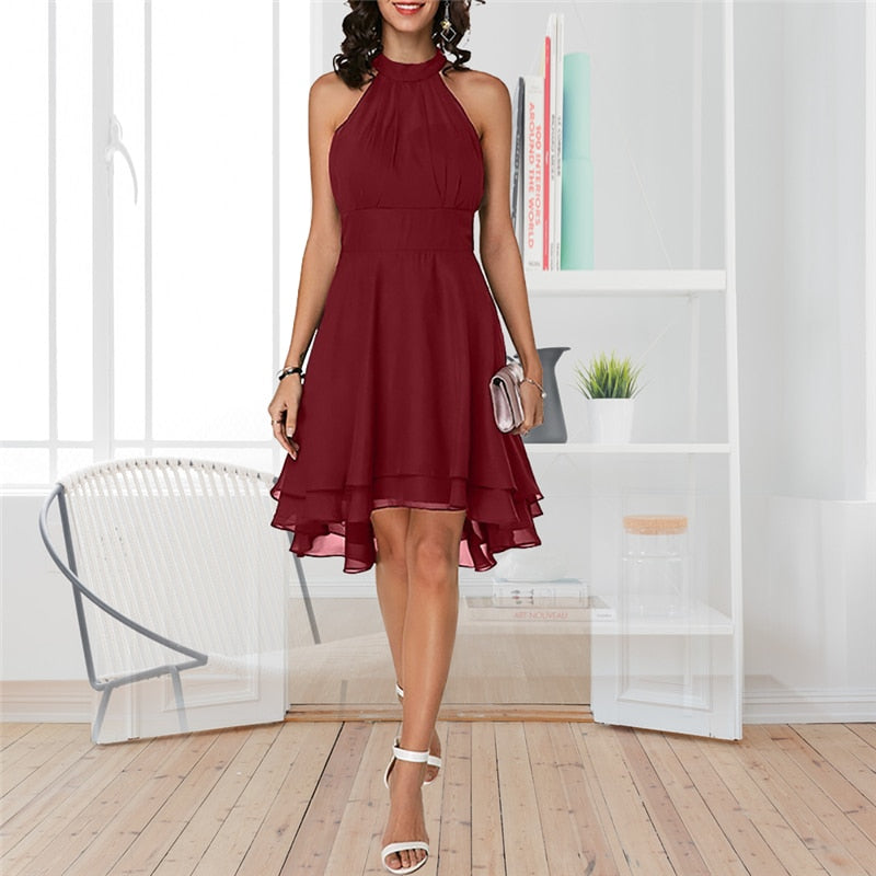 Frau in bordeauxrotem Cocktailkleid, ärmellos, knielang, elegantes Design, in modernem Raum.