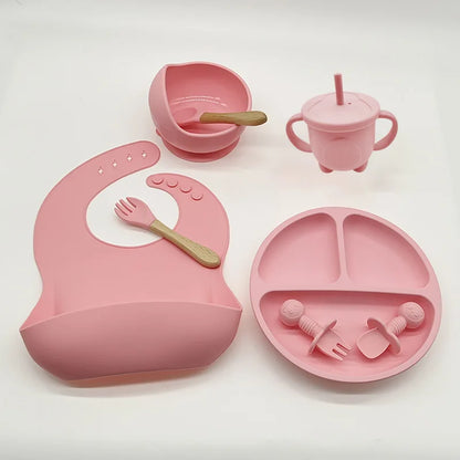 Rosa Silikon-Babyteller-Set mit Lätzchen, Becher, Schüssel und Besteck für Kleinkinder.