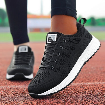 Schwarze Damen-Laufschuhe, atmungsaktiv, rutschfest, auf roter Laufbahn.