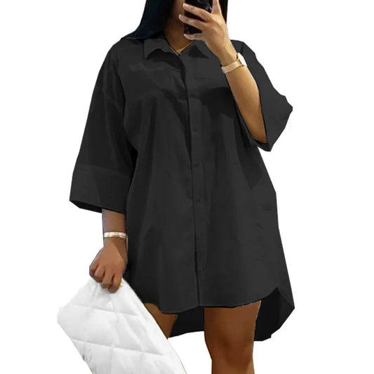 Frau in schwarzem Oversize-Hemd, Handy in der Hand, weiße gesteppte Tasche, modisch.