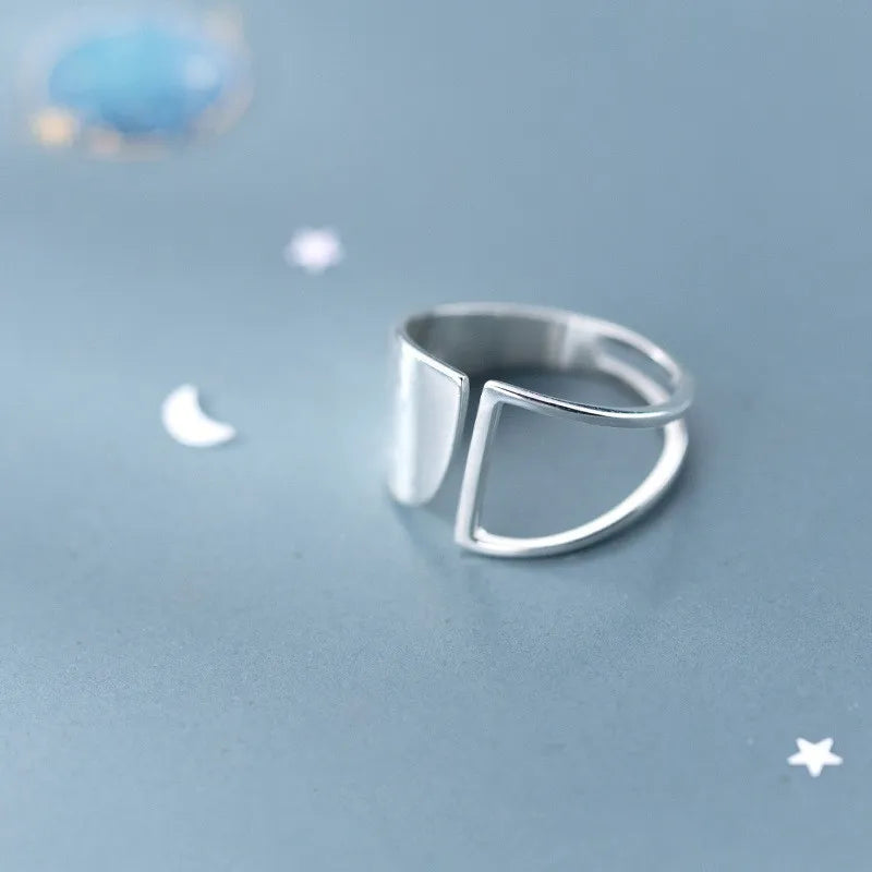 Silberner minimalistischer Ring auf blauem Hintergrund, moderner Schmuck, elegantes Design.