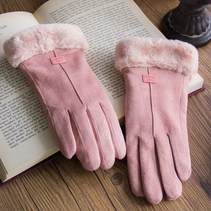 Rosa Damenhandschuhe aus Wildleder mit Kunstfell, elegant, warm, Wintermode, auf Buch liegend.