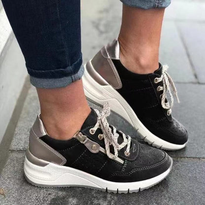 Schwarze Damen-Sneaker mit weißer Sohle und silbernen Akzenten, sportlich, modern, bequem.
