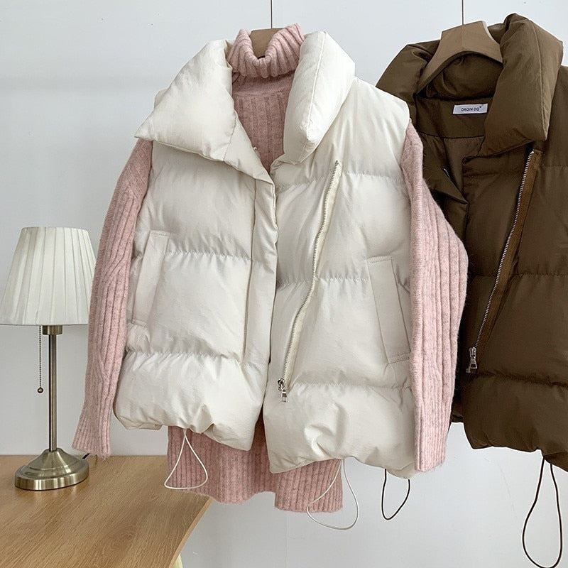 Weiße Daunenweste mit rosa Strickpullover, Damenmode, Herbst-Winter-Outfit, gemütlich.