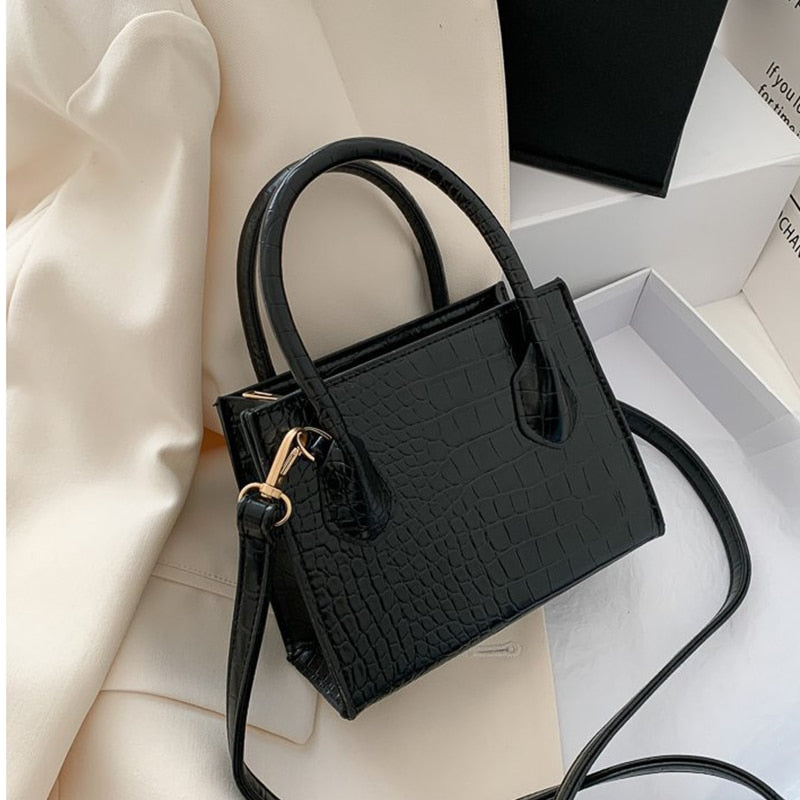 Schwarze Krokodilleder-Handtasche, elegant, Damenmode, Schulterriemen, stilvoll, Accessoire.