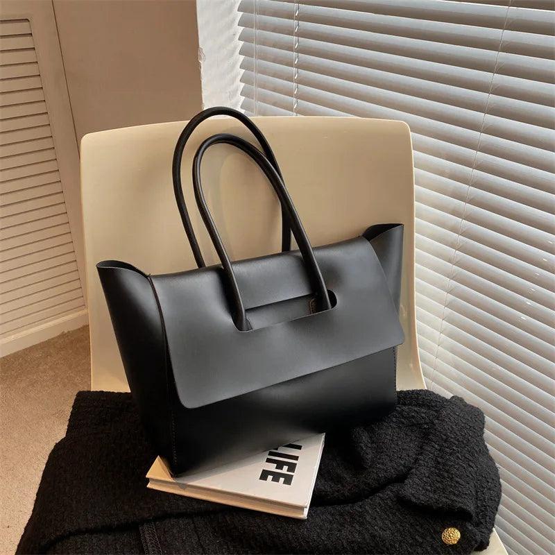 Schwarze Lederhandtasche auf Stuhl, elegantes Design, Damenmode, Accessoire, modern.