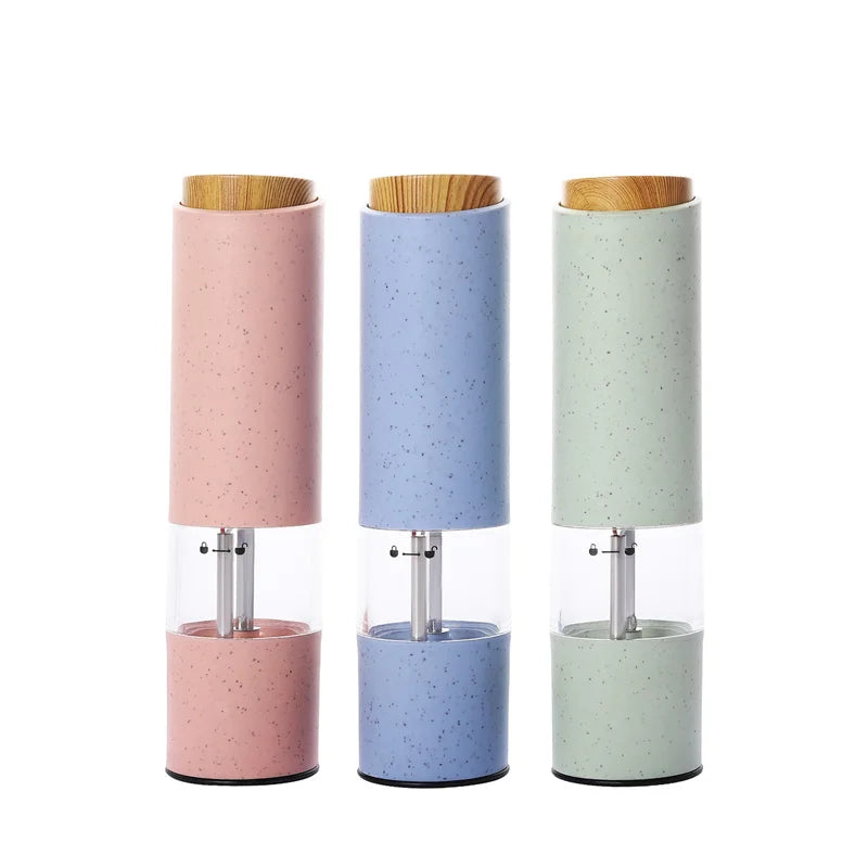 Drei elektrische Salz- und Pfeffermühlen in Rosa, Blau und Grün mit Holzdeckel.