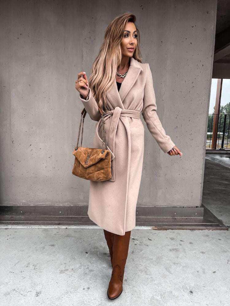 Frau im beigen Wollmantel mit brauner Tasche und Stiefeln, elegantes Herbstoutfit.