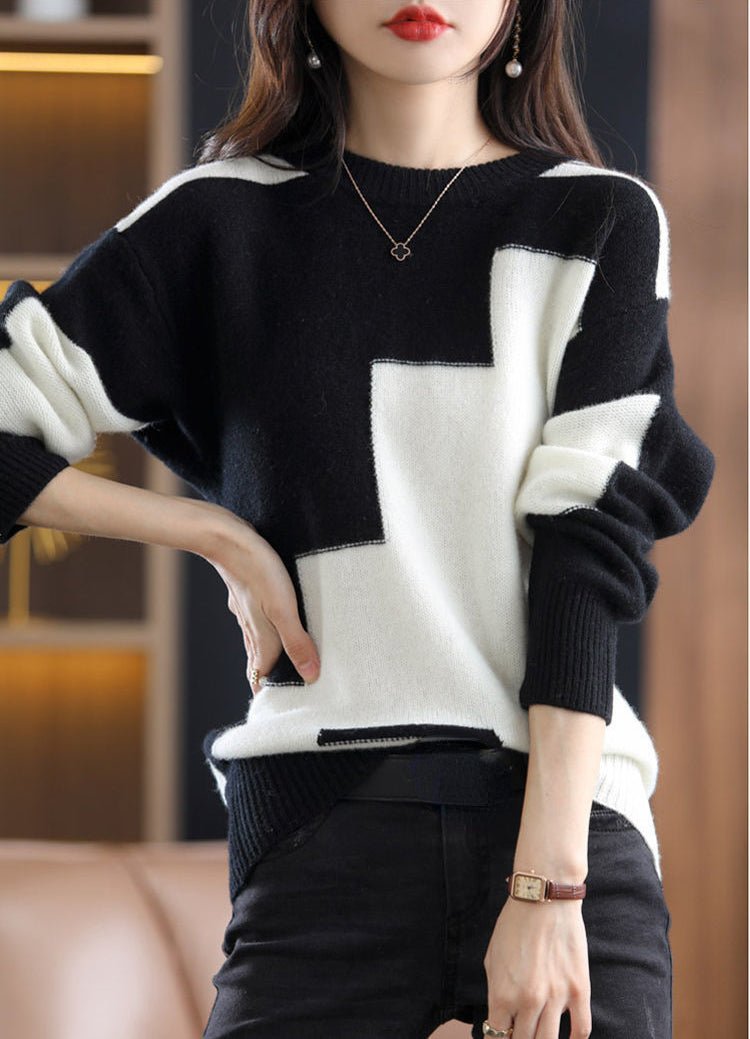 Frau trägt schwarz-weißen Pullover mit geometrischem Muster, modisch, elegant, Herbstmode.