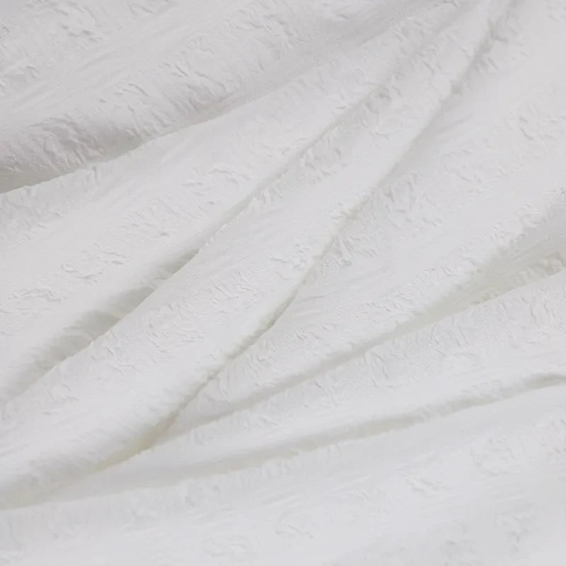 Weiße Jacquard-Stoffstruktur, elegant, hochwertig, ideal für Mode- und Inneneinrichtung.