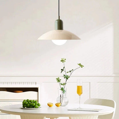 Pendellampa med gräddvit skärm och grön topp ovanför ett runt vitt bord med druvor och glas 6