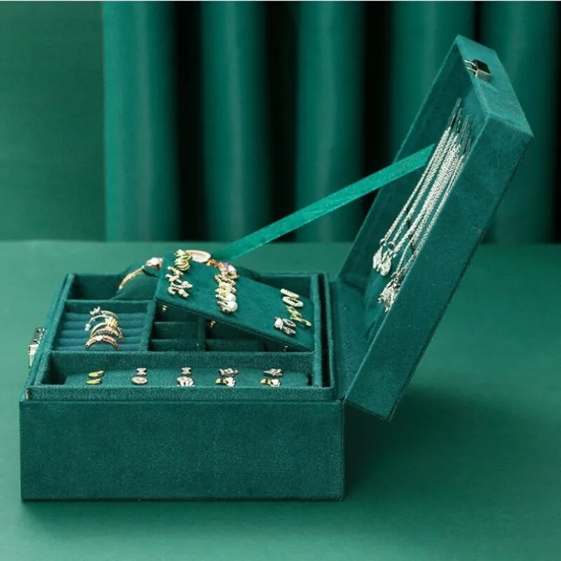 Grüne Schmuckschatulle aus Samt mit Ringen, Ohrringen und Halsketten, luxuriöses Design.