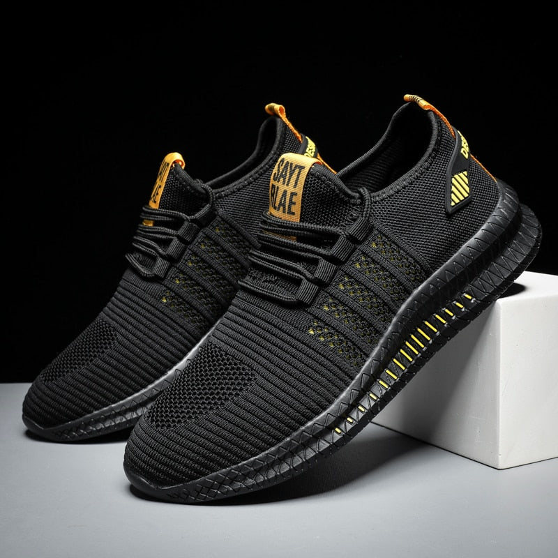 Schwarze Sportschuhe, atmungsaktiv, mit gelben Akzenten, ideal für Laufen und Fitness.