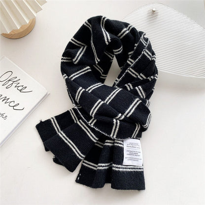Schwarzer Schal mit weißem Karomuster, weiches Material, modisches Accessoire für den Winter.