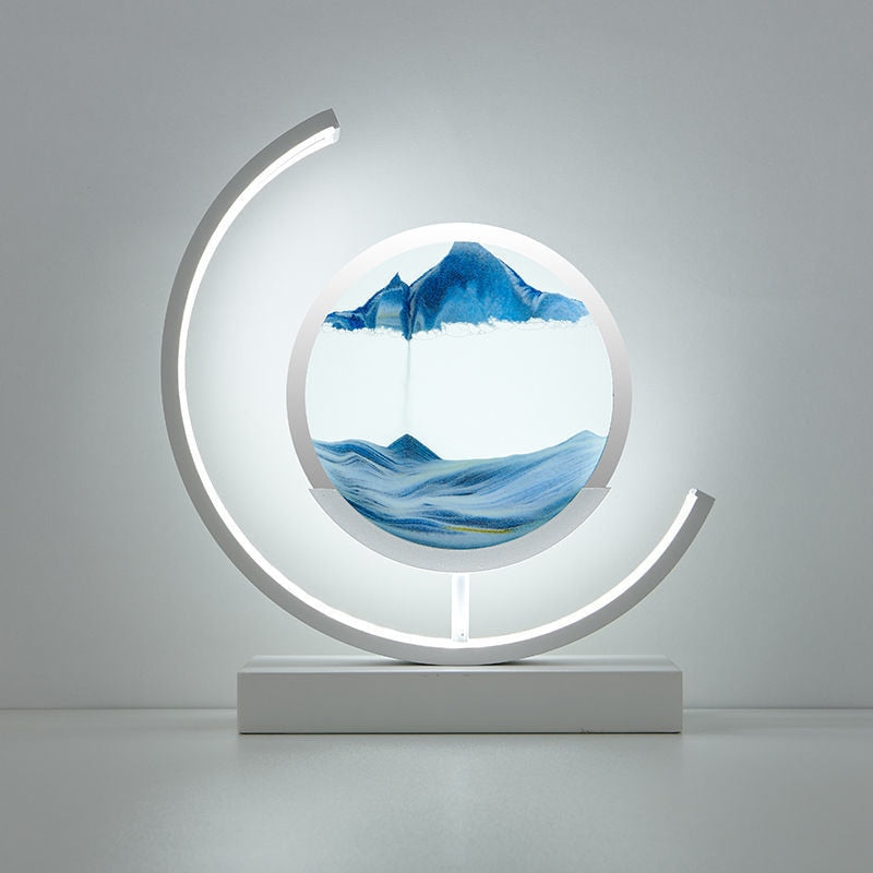 Leuchtende Sanduhr mit blauem Sand und Bergmotiv, dekorative Tischlampe, modern, minimalistisch.