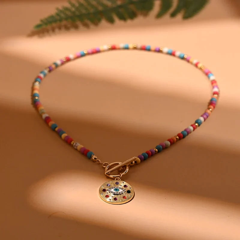 Bunte Perlenkette mit goldfarbenem Anhänger, Damenmode, Schmuckaccessoire, Boho-Stil.