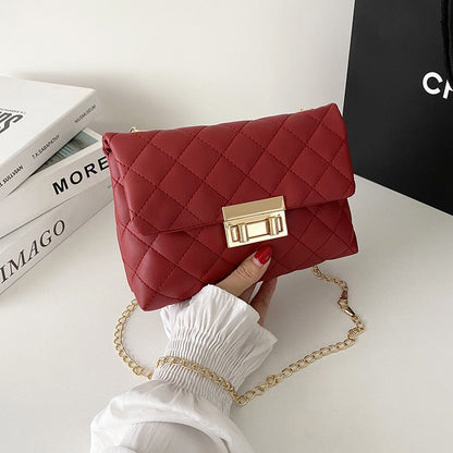 Rote gesteppte Umhängetasche mit goldener Kette und Verschluss, modisches Accessoire.