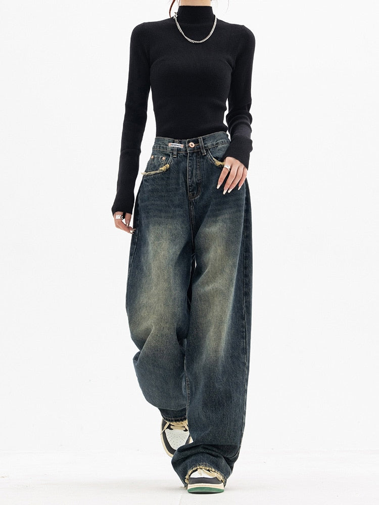 Frau in schwarzem Pullover und weiten Jeans, Streetwear-Mode, lässiger Stil.