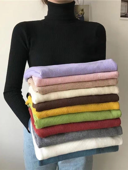 Frau hält Stapel bunter Rollkragenpullover, gerippt, Baumwolle, modisch, Herbstmode.