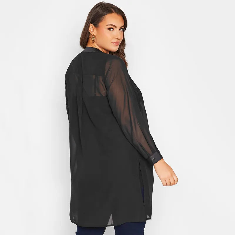 Frau in schwarzer, transparenter Bluse, langärmelig, modisch, elegant, Plus-Size-Mode.