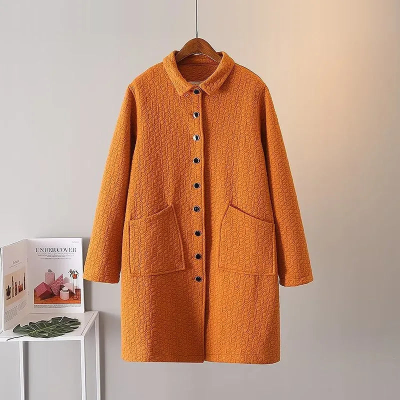Orange Damenmantel mit Knopfleiste, Taschen, Steppmuster, Herbstmode, hängend auf Holzkleiderbügel.