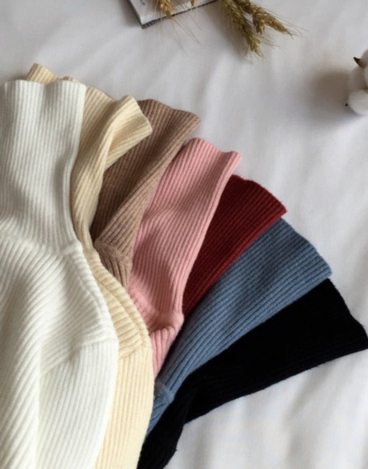 Rippenstrickpullover in Creme, Beige, Rosa, Rot, Blau, Schwarz auf weißem Hintergrund.