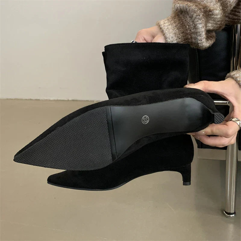Schwarze Wildleder-Stiefeletten mit niedrigem Absatz, spitzem Zeh und rutschfester Sohle.