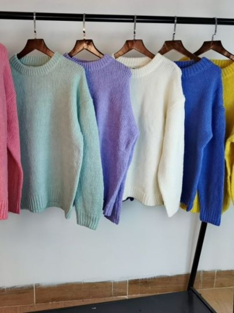 Bunte Strickpullover auf Kleiderbügeln, Pastellfarben, Damenmode, gemütlich, Herbst/Winter.