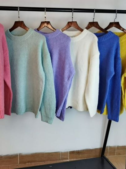 Bunte Strickpullover auf Kleiderbügeln, Pastellfarben, Damenmode, gemütlich, Herbst/Winter.