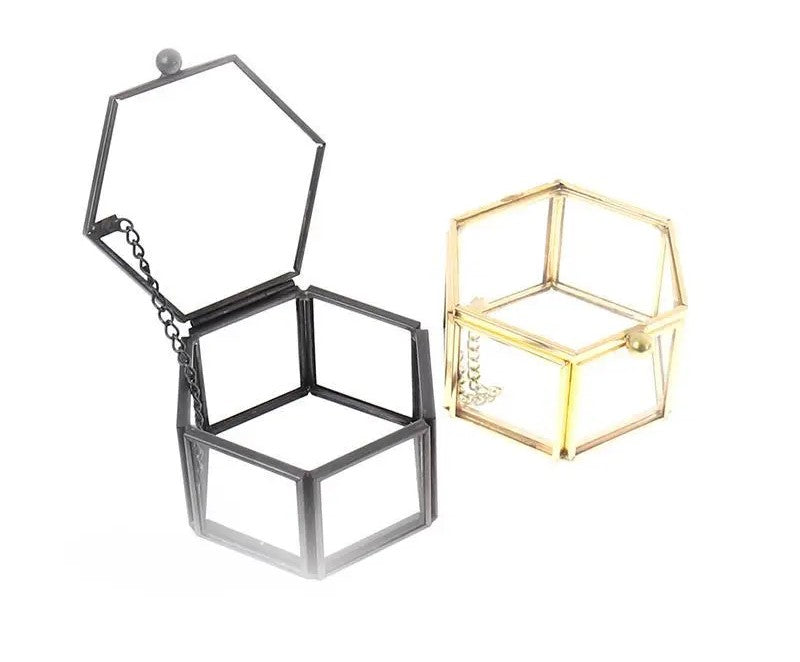 Schwarze und goldene sechseckige Schmuckboxen aus Metall, offen, modern, stilvoll.