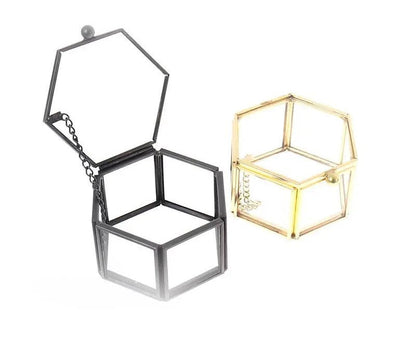 Schwarze und goldene sechseckige Schmuckboxen aus Metall, offen, modern, stilvoll.