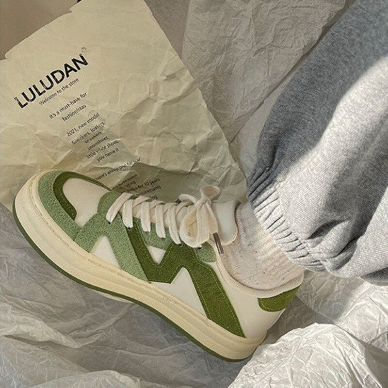 Weiße Sneaker mit grünen Details, LULUDAN, Unisex, Freizeitschuh, modisch, bequem, Stoffhintergrund.