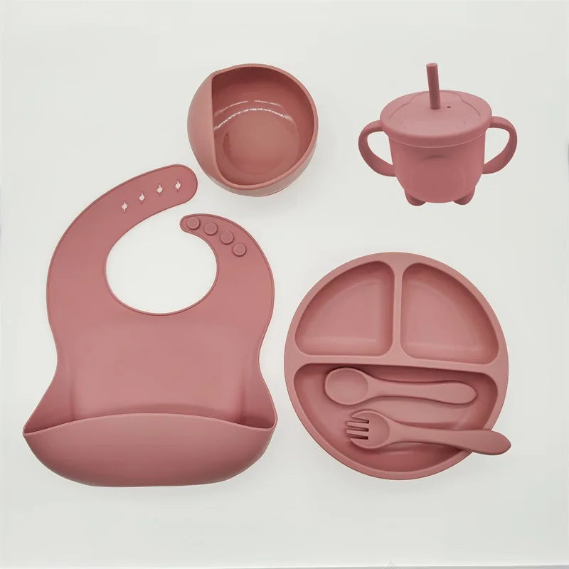 Rosa Silikon-Babygeschirr-Set mit Lätzchen, Teller, Becher und Besteck, BPA-frei.
