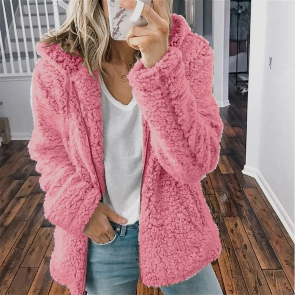 Frau in rosa Teddyfelljacke, weißem T-Shirt und Jeans, modisch, gemütlich, Herbstmode.