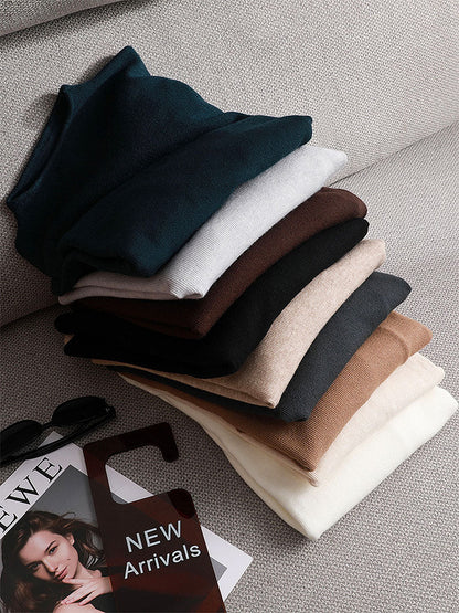 Gestapelte Pullover in verschiedenen Farben auf einem Sofa, Mode, Herbstkollektion, Neuheiten.